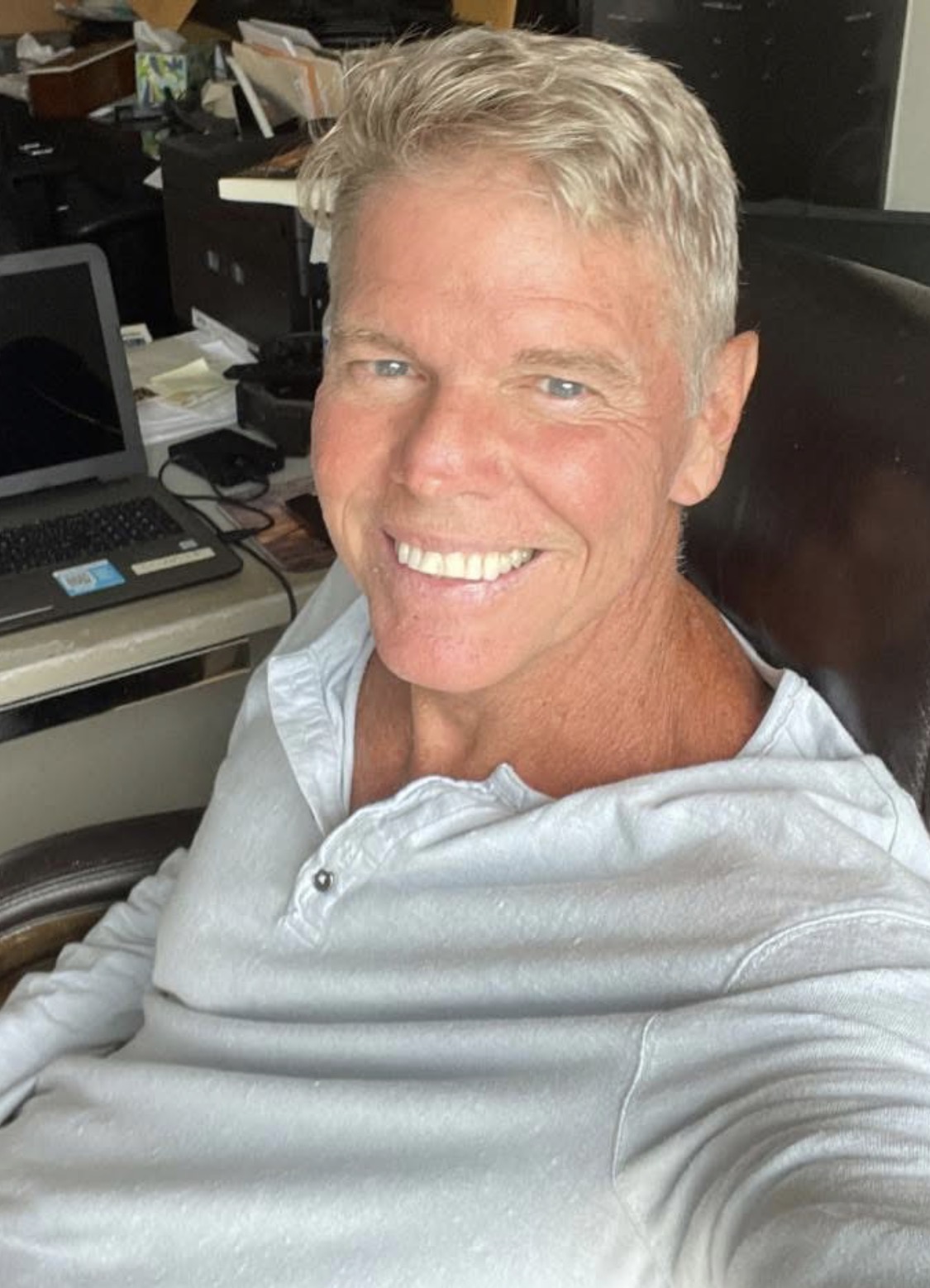 Joel D. Bradley smiling at his desk
